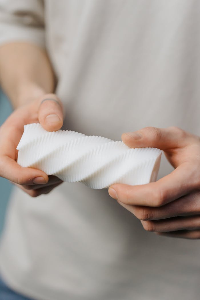 Mastering the First Impression: Your intriguing post title goes here Detailed view of hands grasping a modern spiral-shaped plastic piece.